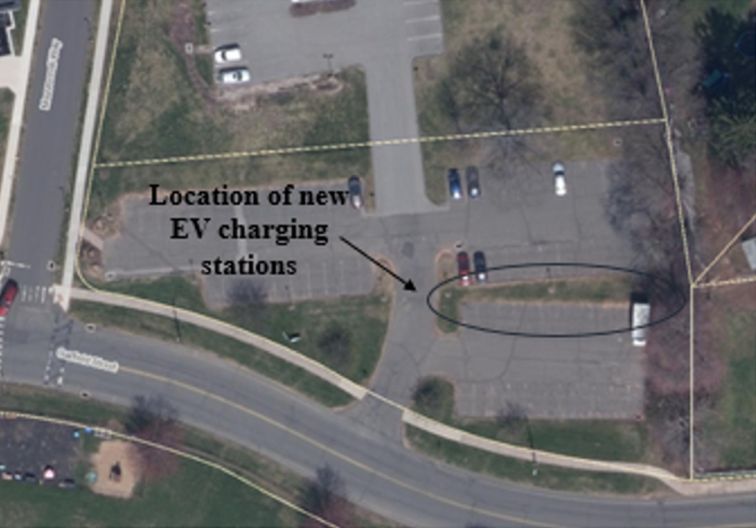 Picture of parking lot with an arrow showing where the Ev charging stations are being installed.