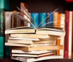 Stack of library books with open book on top