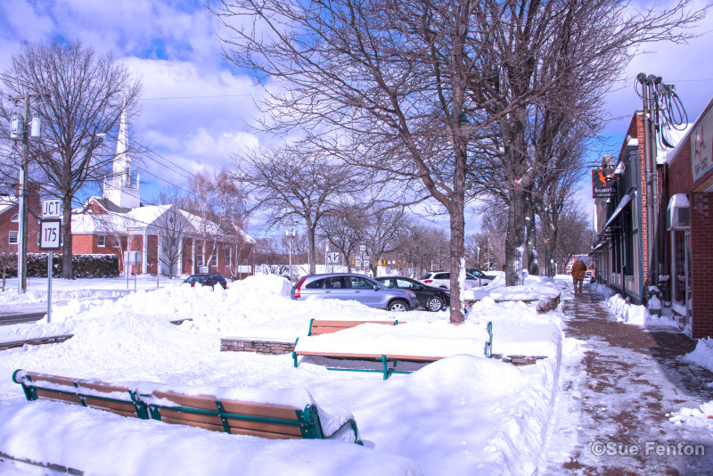 View of snow on and around sidewalks in front of downtown businesses
