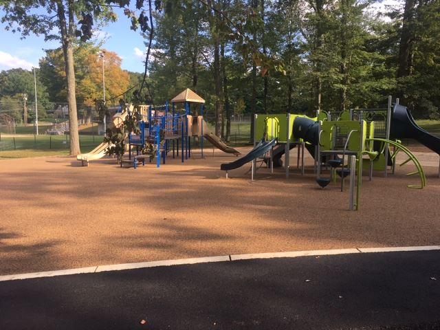 Newly renovated Churchill Park Playground with green play structure and blue/tan play structure