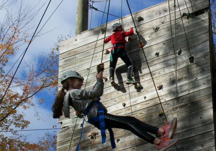2 people climbing on the climbing wall at Newington's challenge course