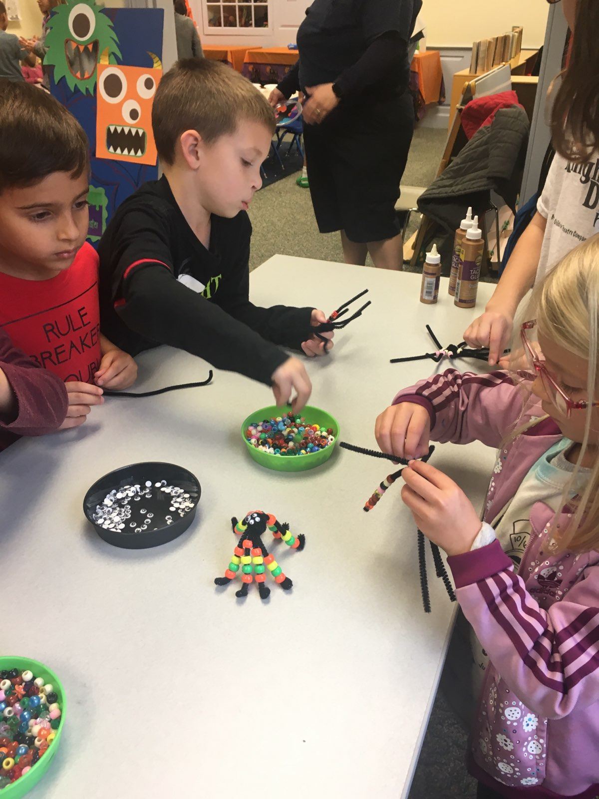 children making pipe cleaner spider crafts