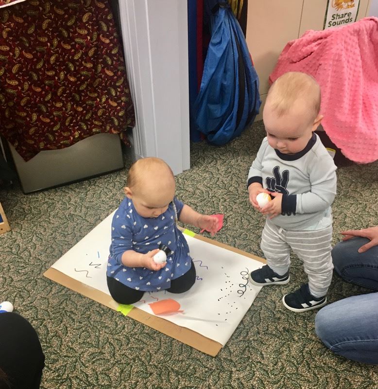 toddler girl and boy coloring with markers