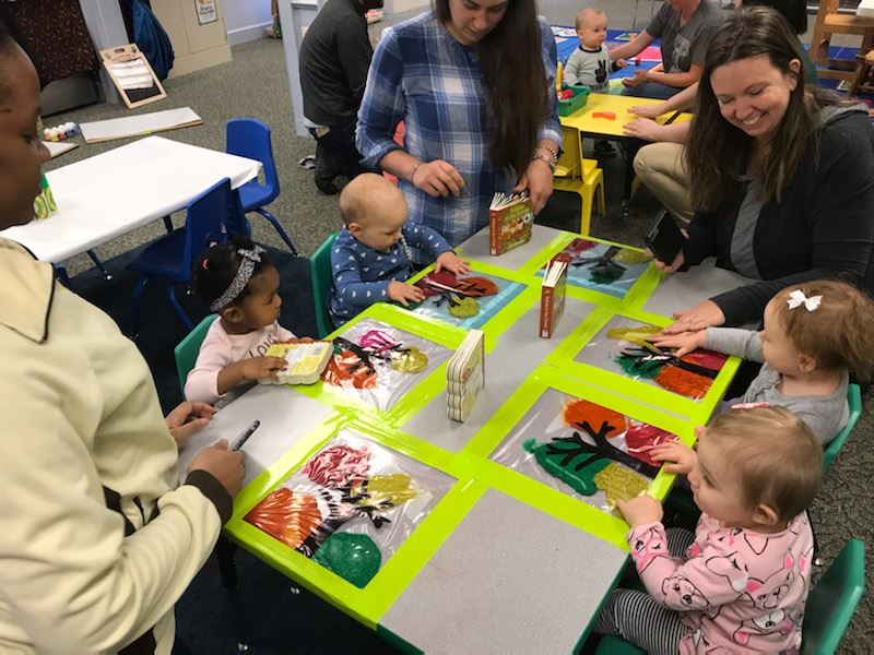 babies mixing fall colors in bag on table