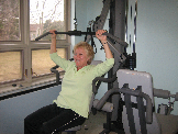 Woman doing the pull down weight machine
