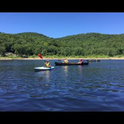 Two kayaks on reservoir with green mountain in background