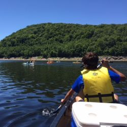 kayaks on reservoir with green mountain in background